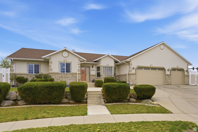 5169 West Rock Ridge Lane West Jordan, UT 84081 - Photo 1 of 1 View of front of home featuring an attached garage, stucco siding, concrete driveway, and stone siding