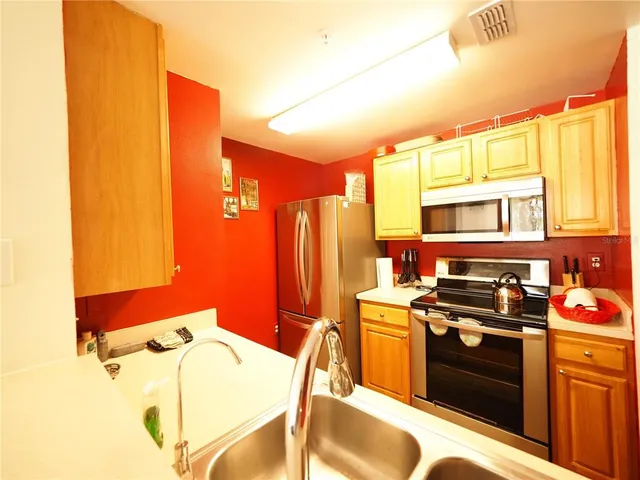 a kitchen with stainless steel appliances granite countertop a stove a sink and a refrigerator