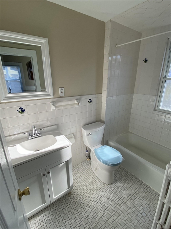 253 Whitwell Street, Unit 2R Quincy, MA 02169 - Photo 12 of 12 a bathroom with a sink toilet a mirror and vanity
