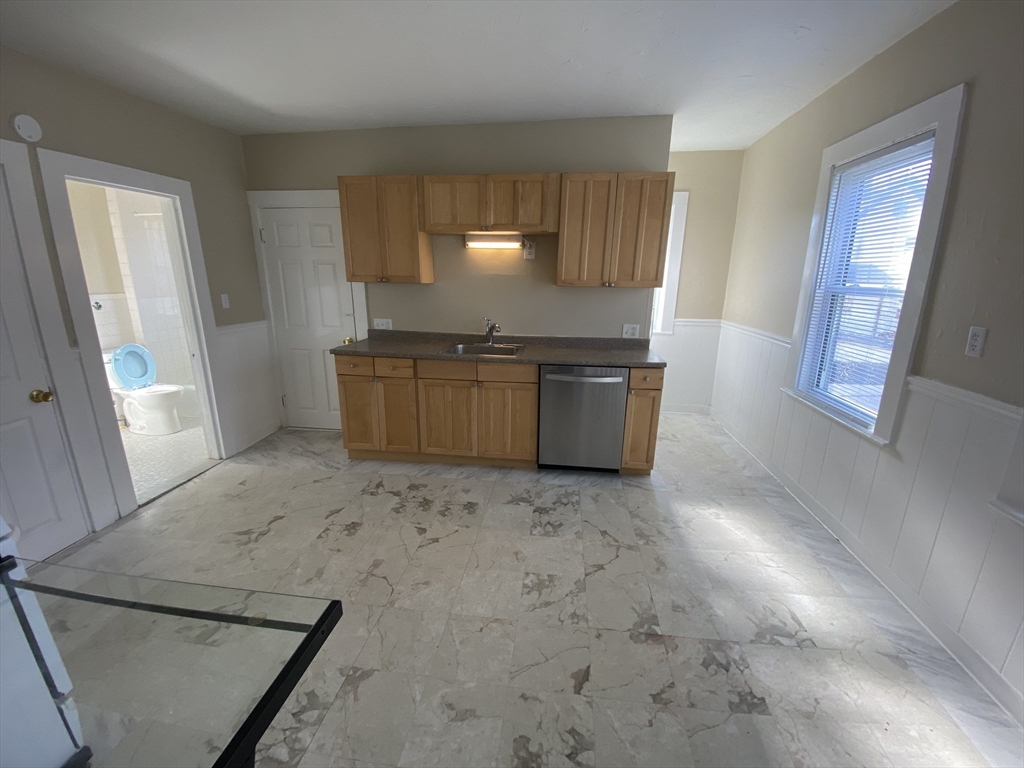 253 Whitwell Street, Unit 2R Quincy, MA 02169 - Photo 5 of 12 a open kitchen with granite countertop a sink and a stove top oven