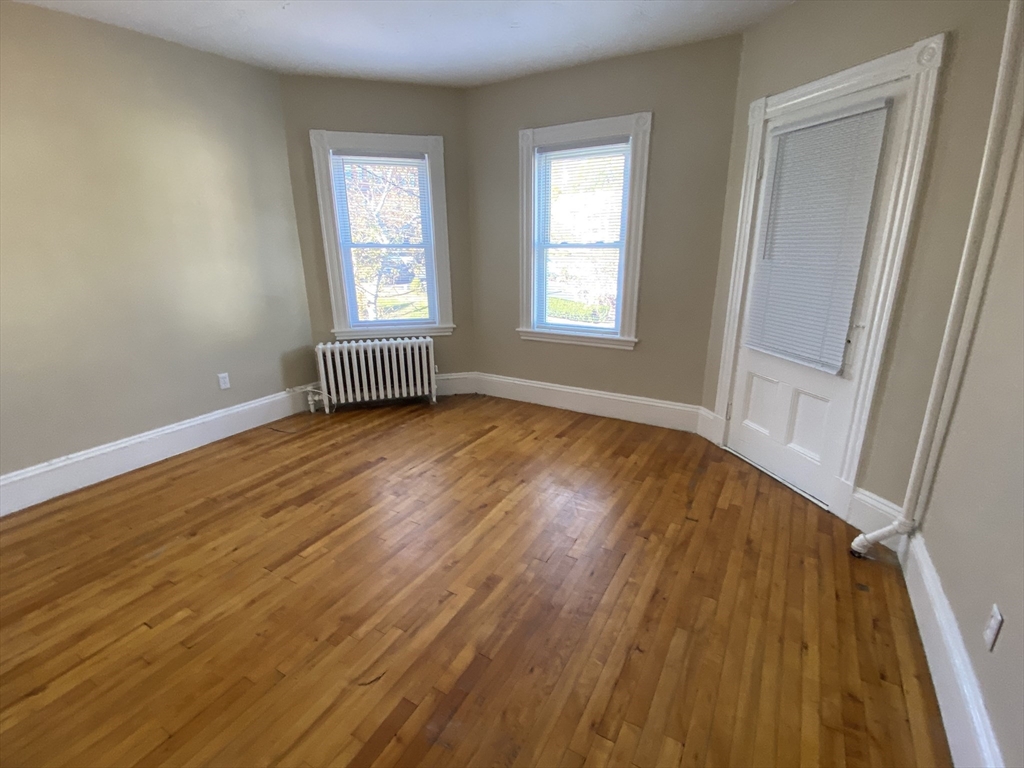 253 Whitwell Street, Unit 2R Quincy, MA 02169 - Photo 6 of 12 a view of an empty room with wooden floor and a window