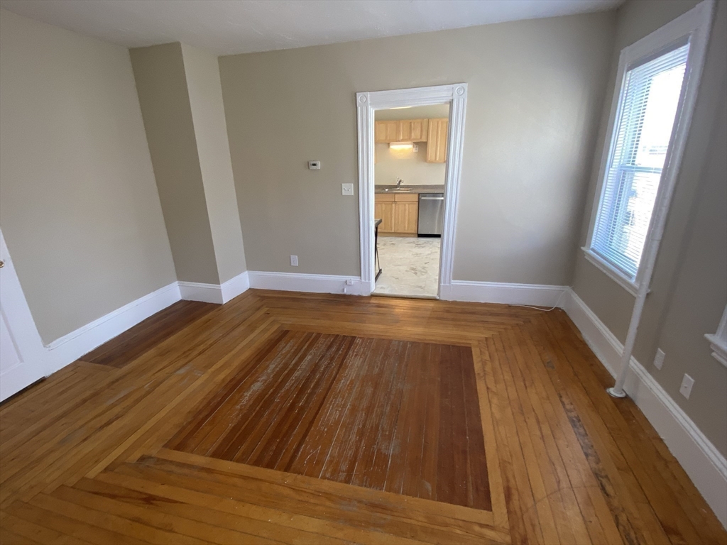 253 Whitwell Street, Unit 2R Quincy, MA 02169 - Photo 8 of 12 an empty room with wooden floor and windows