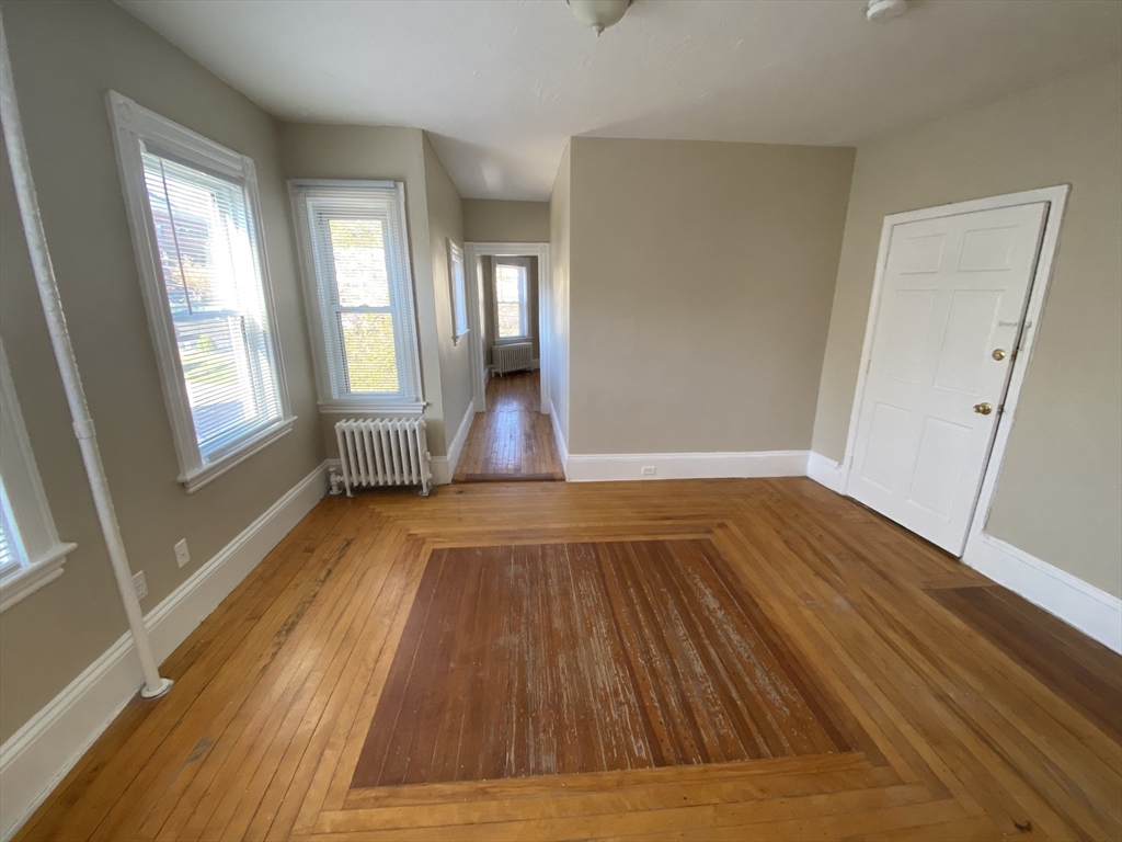 253 Whitwell Street, Unit 2R Quincy, MA 02169 - Photo 10 of 12 an empty room with wooden floor and windows