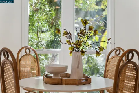 a vase of flowers sitting on a table with potted plants