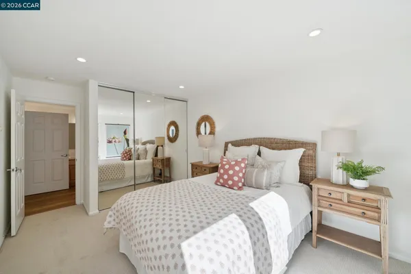 a bedroom with a bed and a large mirror