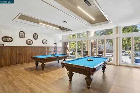 a living room with furniture pool table and a large window
