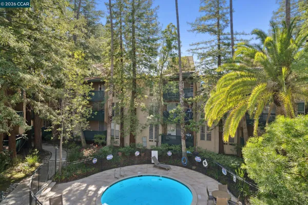 a view of yard with swimming pool and trees in the background