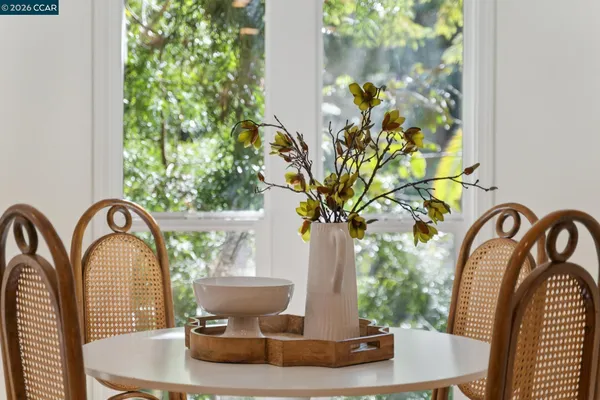a vase of flowers sitting on a table with potted plants