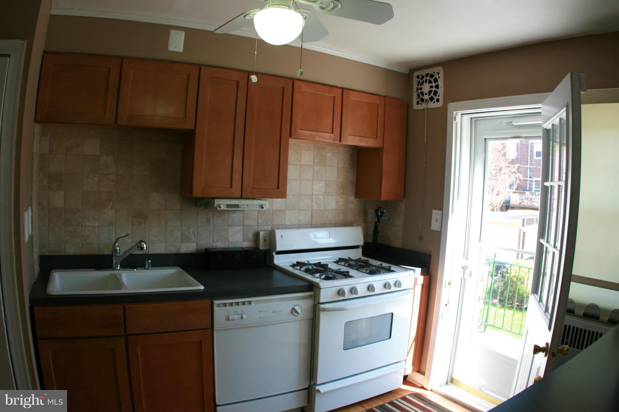 429 Academy Road Catonsville, MD 21228 - Photo 12 of 26 a kitchen with granite countertop a stove a sink a refrigerator and wooden cabinets