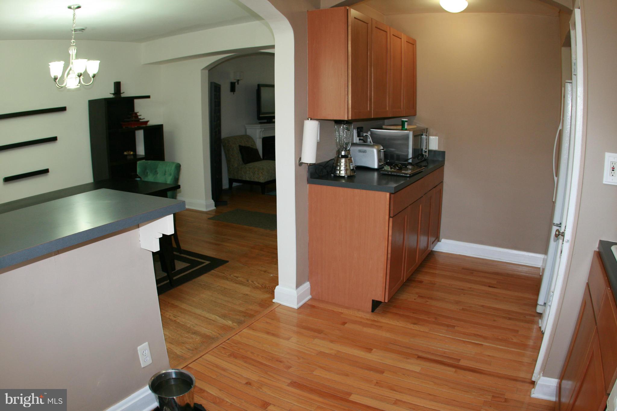 429 Academy Road Catonsville, MD 21228 - Photo 8 of 26 a kitchen with granite countertop a refrigerator and a wooden floor
