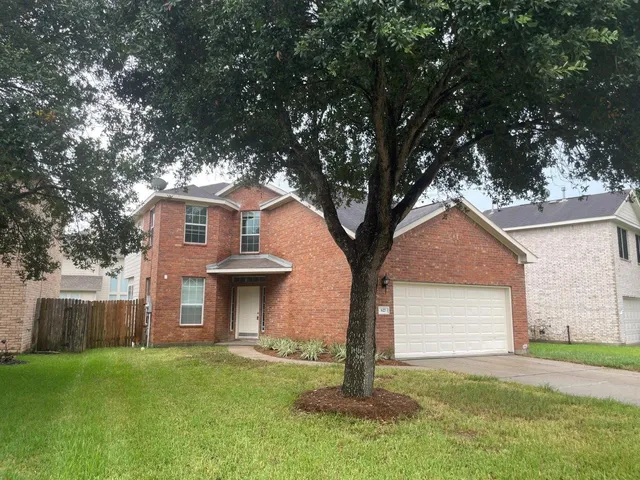 a front view of a house with a garden and yard