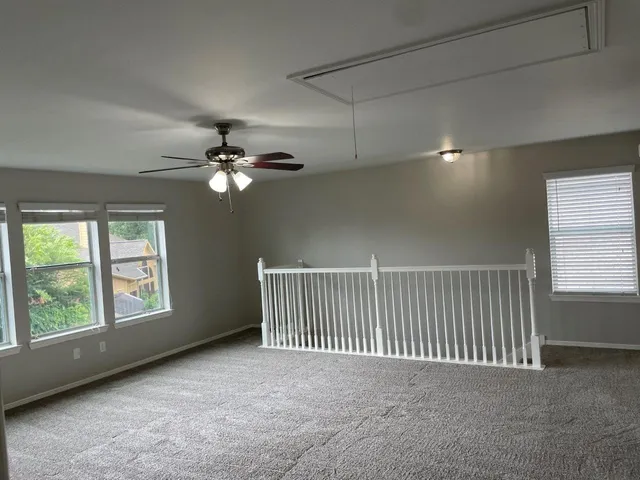a view of a livingroom with a ceiling fan and window