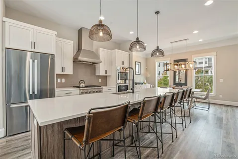 a kitchen with stainless steel appliances granite countertop a stove a refrigerator a oven a kitchen island a sink cabinets and a refrigerator