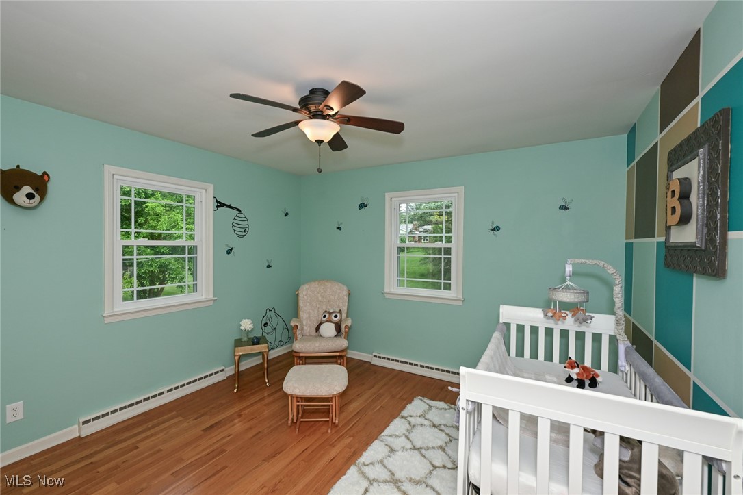 2015 Burlington Road Akron, OH 44313 - Photo 28 of 50 Bedroom featuring a baseboard radiator, multiple windows, and wood finished floors