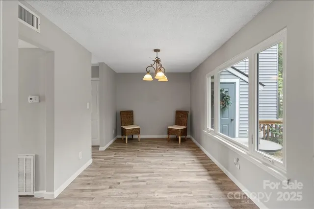 a view of dining room with wooden floor and chairs