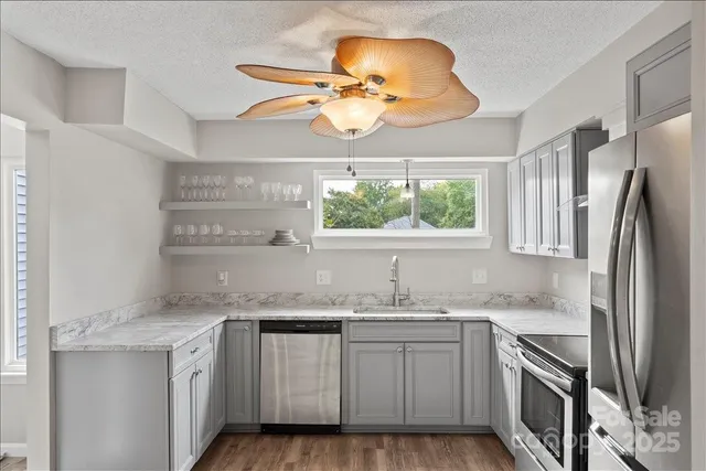 a kitchen with stainless steel appliances granite countertop a sink cabinets and window