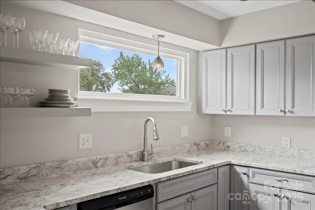 a kitchen with stainless steel appliances granite countertop a sink a window and cabinets