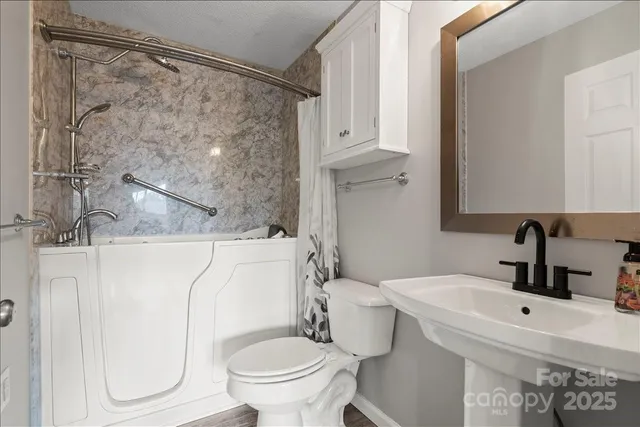 a bathroom with a sink toilet and shower