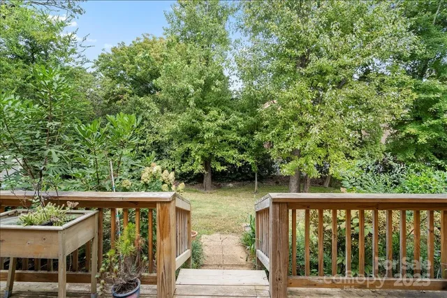 a view of a wooden deck with chairs next to a yard