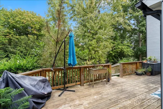 a view of deck with furniture and trees in the background