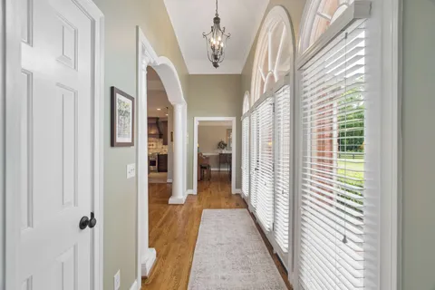 a dining room with furniture a chandelier and wooden floor