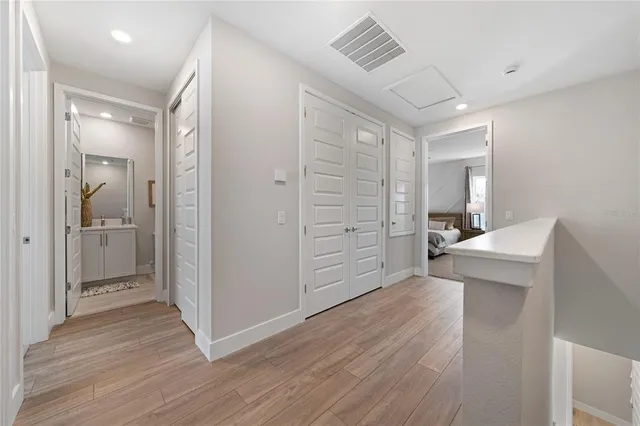 a view of a hallway with bathroom and wooden floor