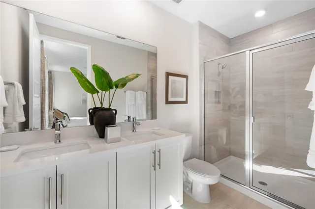 a bathroom with a granite countertop sink a toilet and shower
