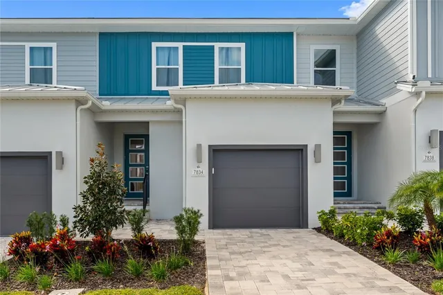 a front view of house and yard with beautiful flowers