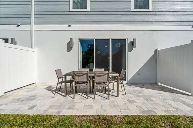 a view of a patio with table and chairs and floor to ceiling window