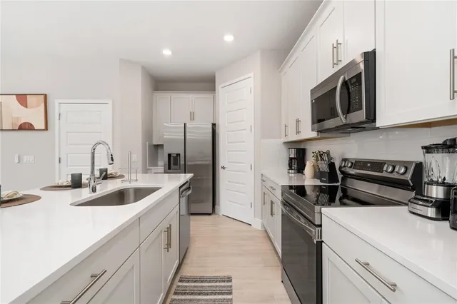 a kitchen with stainless steel appliances granite countertop a sink and a stove