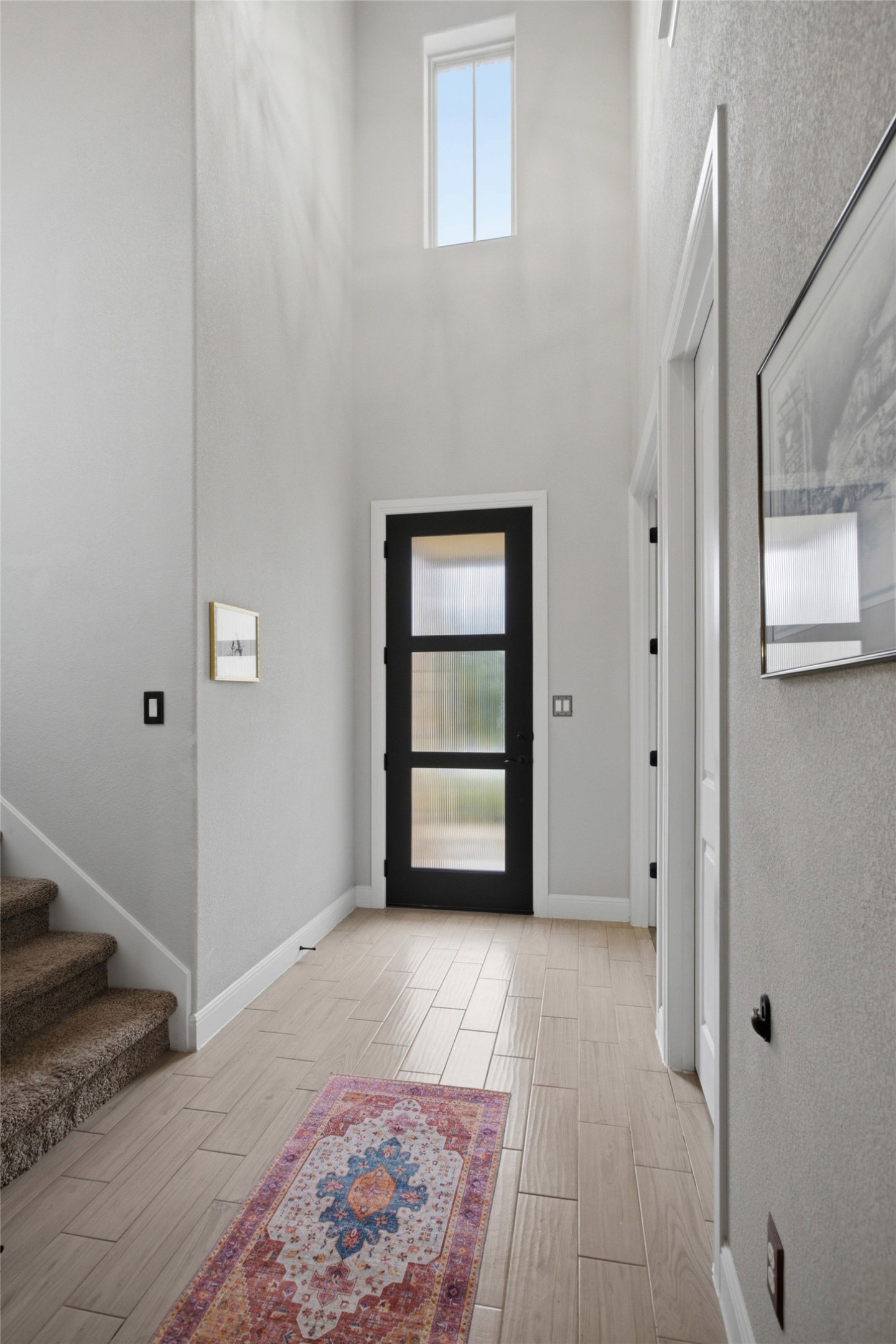 1113 Modoc Way Kyle, TX 78640 - Photo 3 of 34 A well-lit entry hall with a tall window and contemporary door welcomes residents.