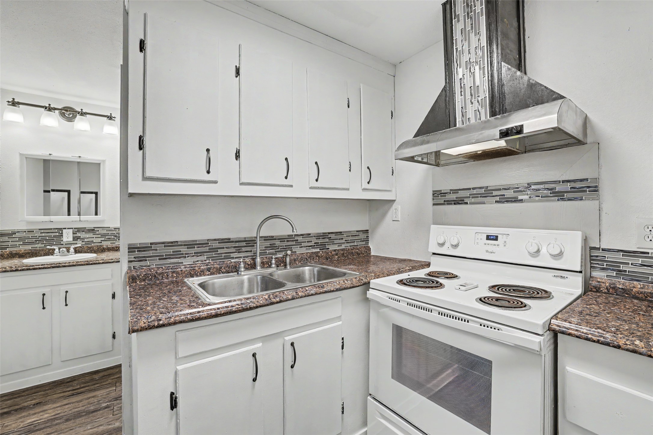 6307 Chesterfield Avenue Austin, TX 78752 - Photo 17 of 20 a kitchen with granite countertop a sink a stove and cabinets