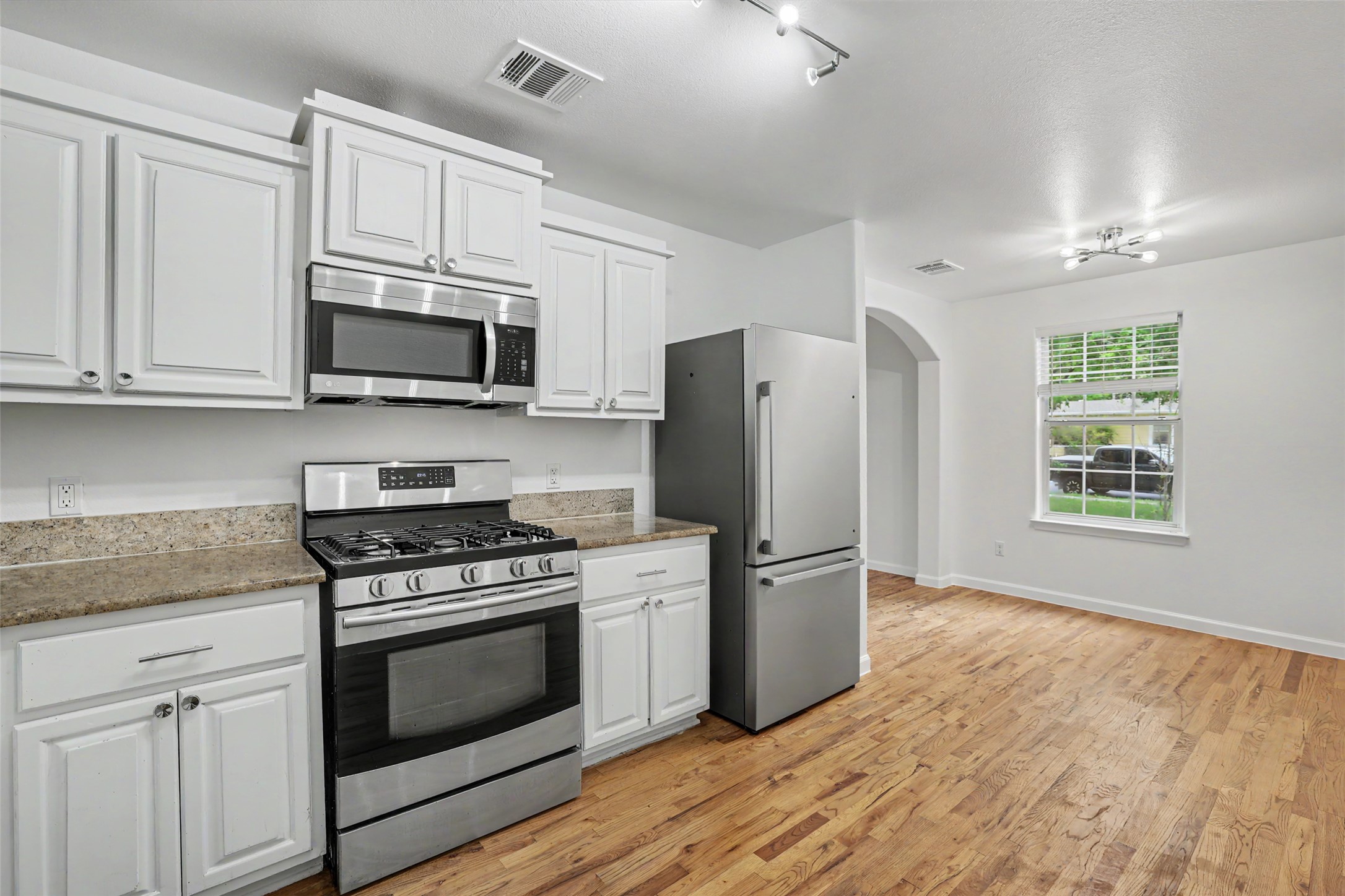 6307 Chesterfield Avenue Austin, TX 78752 - Photo 4 of 20 a kitchen with stainless steel appliances granite countertop a stove a refrigerator and a microwave
