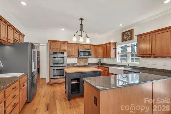 a kitchen with stainless steel appliances granite countertop a sink a stove and a refrigerator
