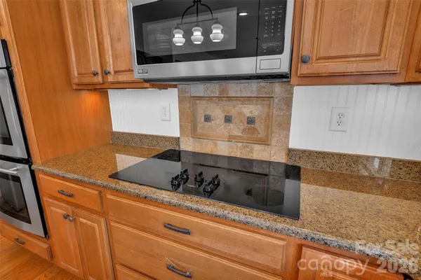 a kitchen with granite countertop white cabinets and black appliances