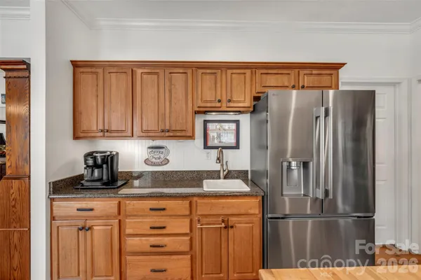 a kitchen with granite countertop stainless steel appliances a refrigerator and cabinets