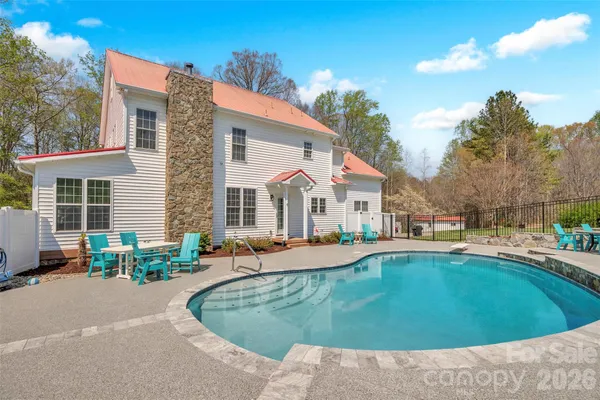 a view of a house with swimming pool and sitting area
