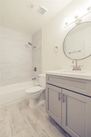 a bathroom with a toilet a sink a mirror and vanity