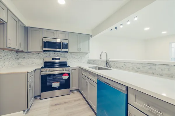 a kitchen with a sink and a stove top oven
