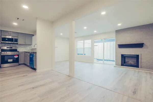 a view of kitchen with kitchen island granite countertop a stove top oven a sink and a counter top space
