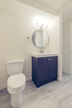 a bathroom with a toilet a sink and mirror