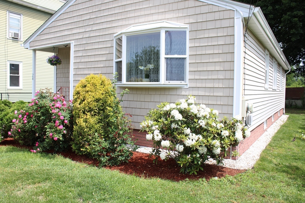28 State Street Chicopee, MA 01013 - Photo 2 of 25 a front view of a house with a yard with flower garden