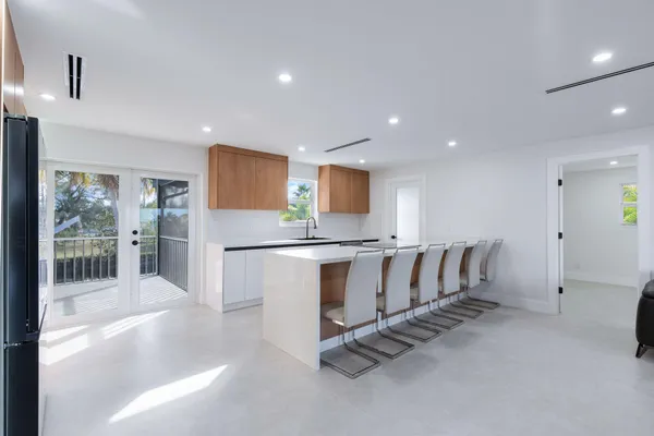 a large kitchen with stainless steel appliances a sink a stove and a refrigerator