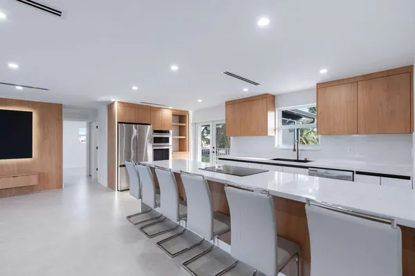 a kitchen with stainless steel appliances a sink a counter top space cabinets and a window