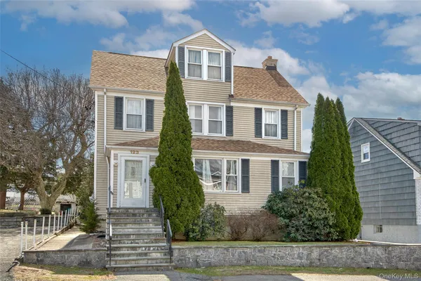 a front view of a house with a yard and trees