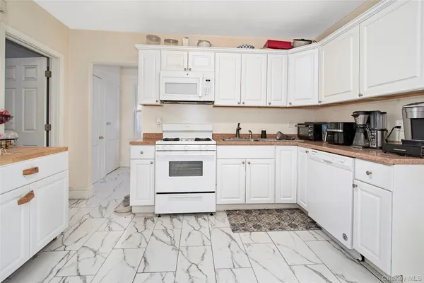 a kitchen with white cabinets appliances and sink