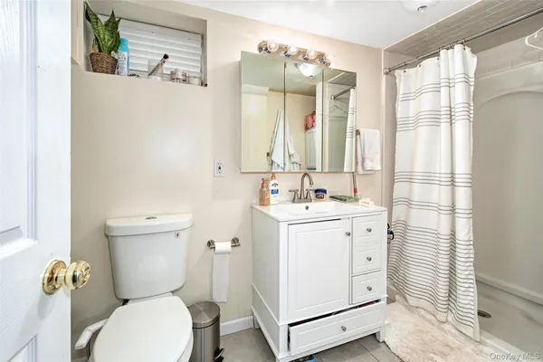 a bathroom with a granite countertop toilet a sink and a mirror