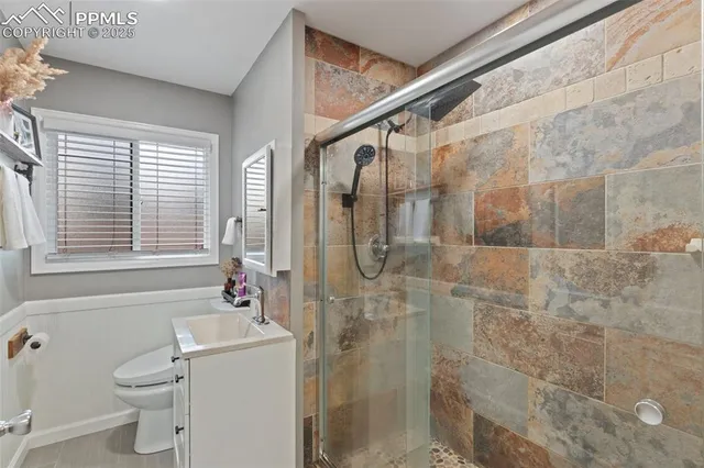 a bathroom with a granite countertop shower a sink and a toilet