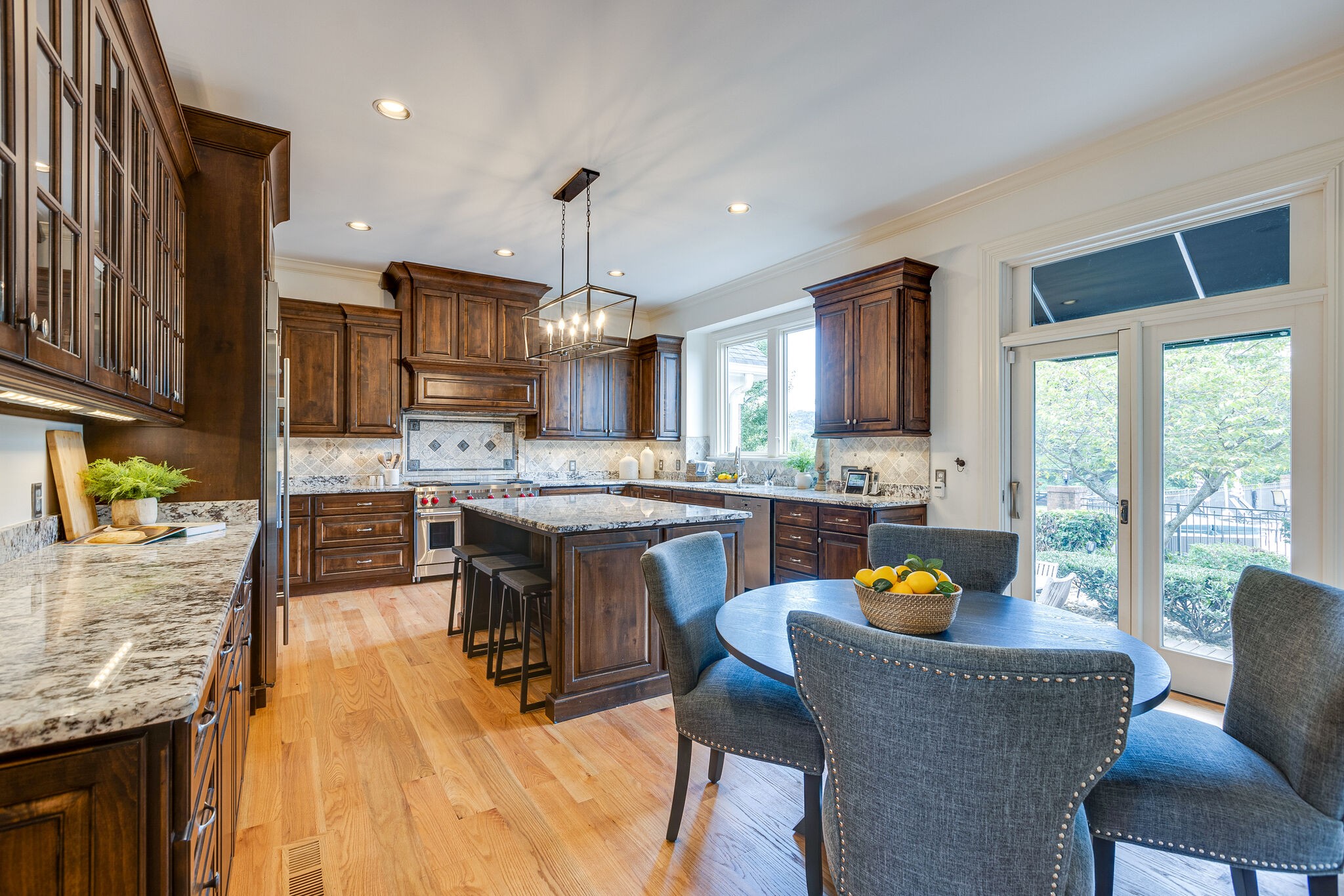 9501 Clovercroft Road Franklin, TN 37067 - Photo 23 of 70 a kitchen with stainless steel appliances granite countertop a stove a sink dishwasher a dining table and chairs with wooden floor