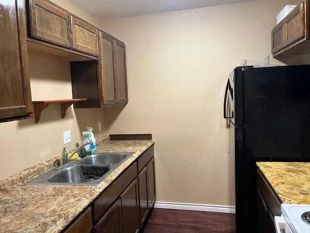 a kitchen with stainless steel appliances granite countertop a sink and a refrigerator